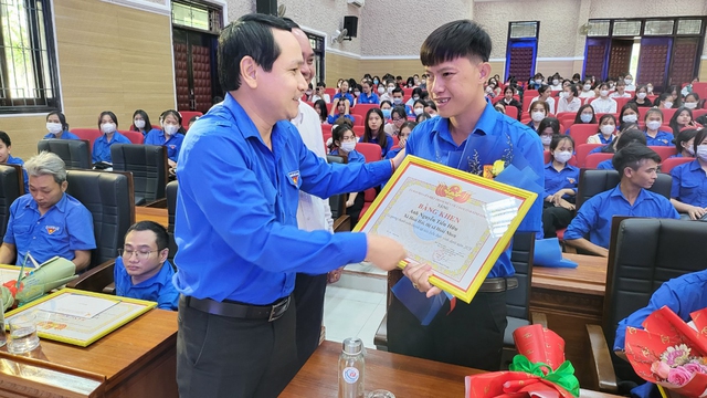 Anh Hà Duy Trung, Bí thư Tỉnh đoàn Bình Định (bìa trái), trao bằng khen cho 1 thanh niên khuyết tật tiêu biểu